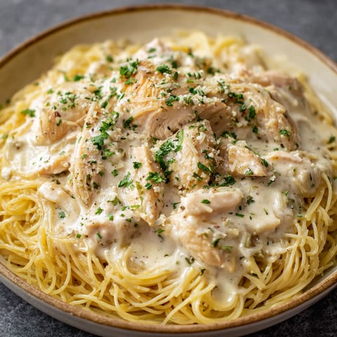 A delicious meal of chicken and pasta, likely a Crockpot Angel Chicken Delight, served in a bowl.