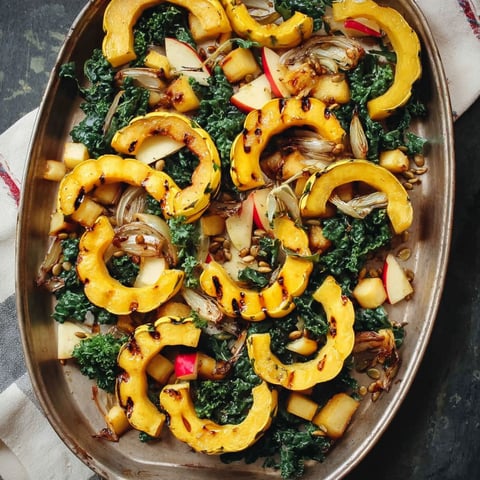A delicious dish of roasted delicata squash with apples and greens.