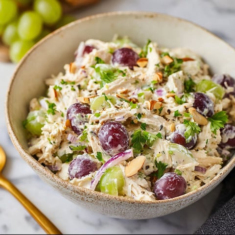 A bowl of Greek Yogurt Chicken Salad is displayed on a table.