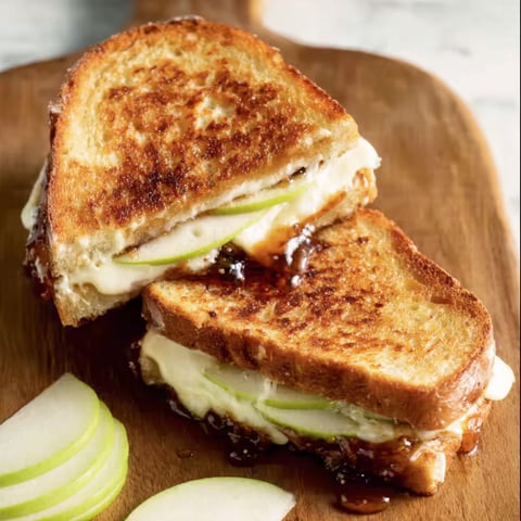 A delicious grilled sandwich made with brie, green apples, and fig jam.