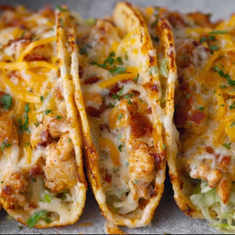 Two delicious baked chicken bacon ranch tacos on a plate.