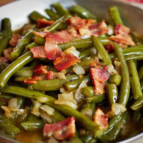 A dish of Southern Green Beans with bacon and onions, served in a bowl.